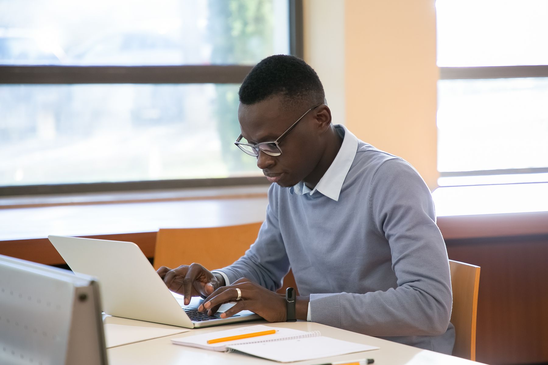 Student working at a laptop with study materials